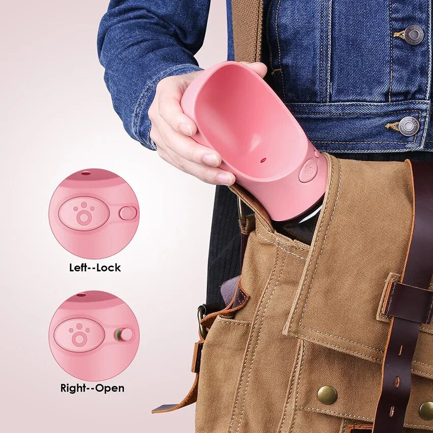 Dog using pink travel water bottle on walk